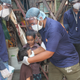 Asha warrior puts a mask on a child in the slum
